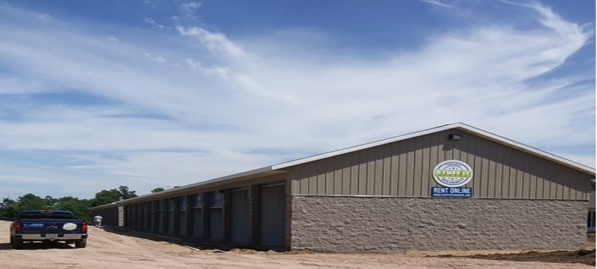 Long row of storage units with a Stuff it Storage sign and Rent Online banner