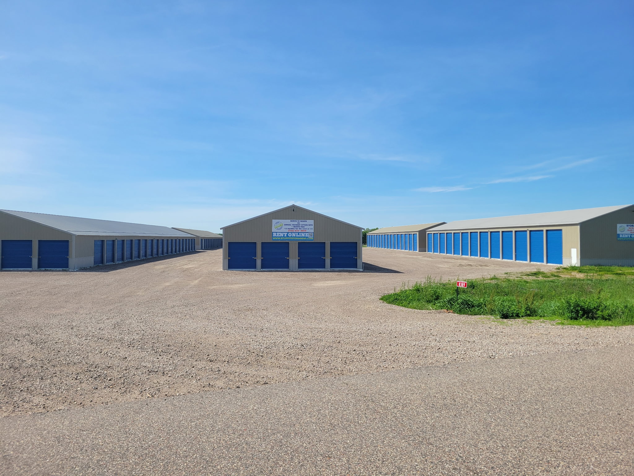 Marshfield storage facility with rows of blue roll-up doors around a gravel lot