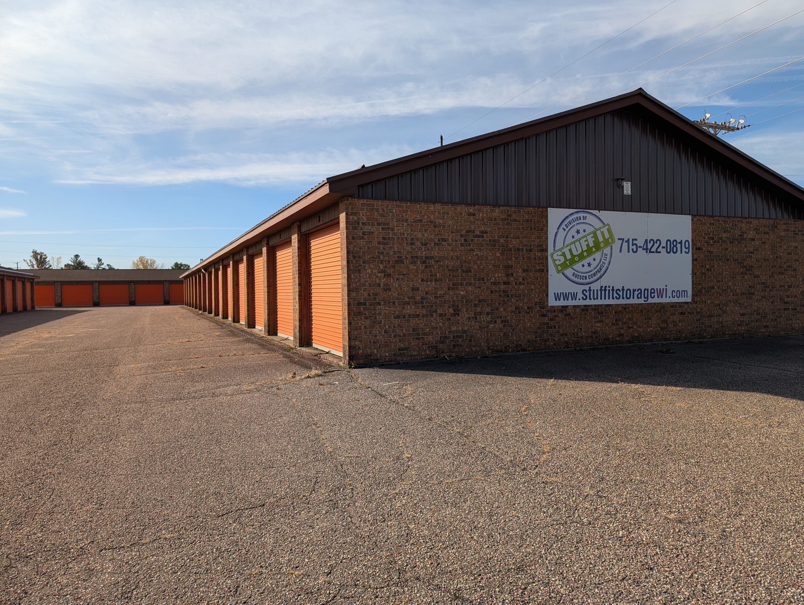 Brick storage buildings with orange roll-up doors and a Stuff it Storage sign at the 36th Street / Plover Road location